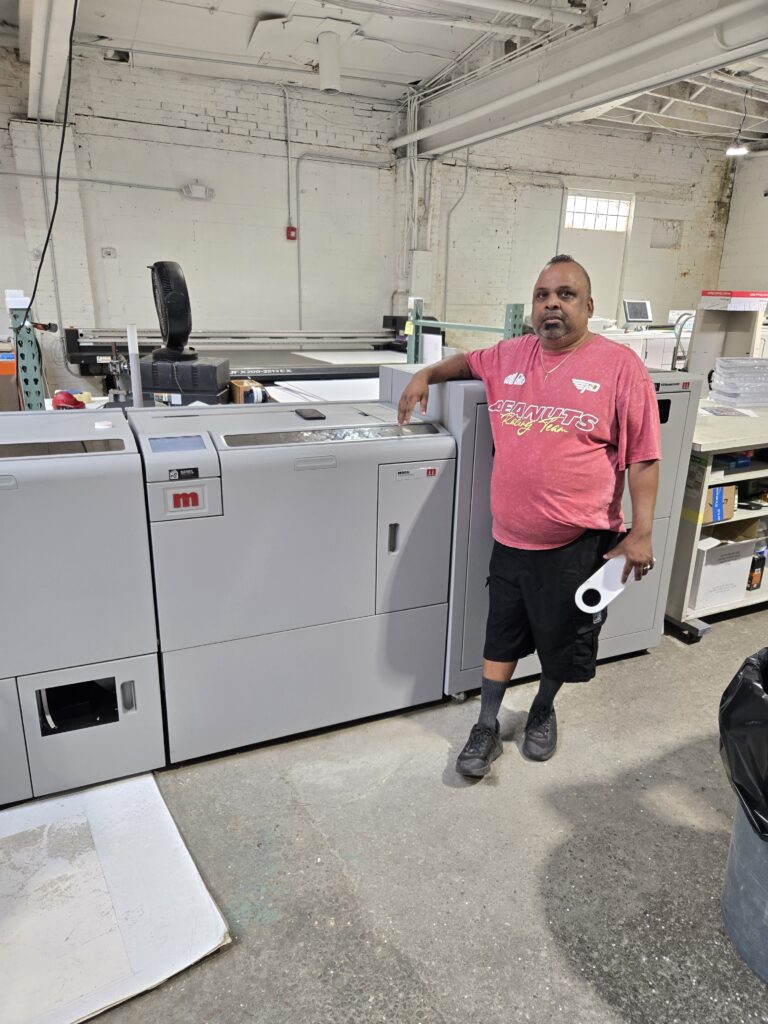 Naresh Persuad of EZ Printing & Binding with the Morgana/Plockmatic BM 5050S square back bookletmaker
