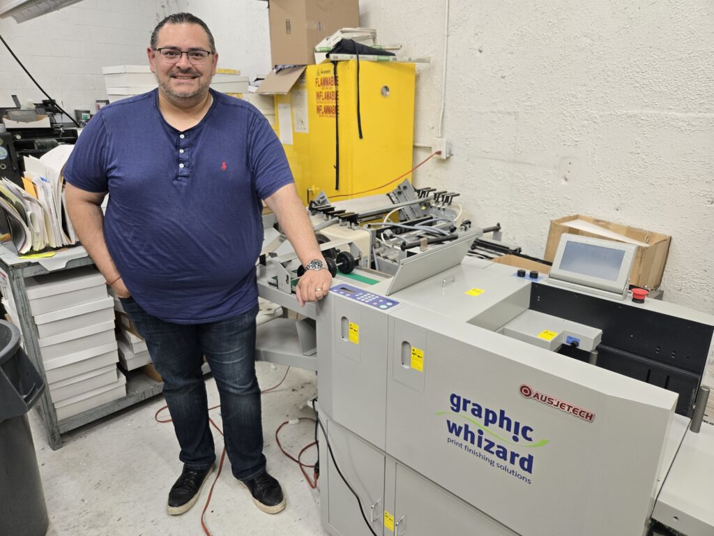 Ali Baqueri of Sir Speedy Plainview with the Graphic Whizard PT335AKF automatic creaser/folder